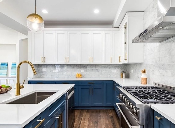 Kitchen remodel with white uppers, navy lowers, and gold fixtures